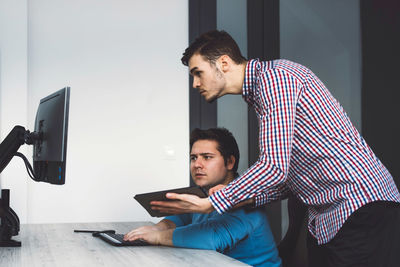 Side view of man using laptop at home