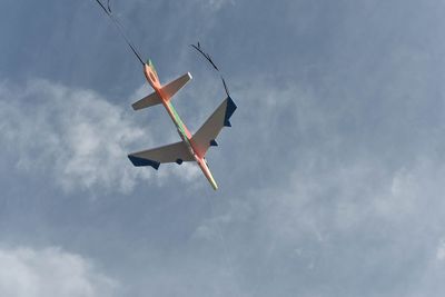 Low angle view of airplane flying against sky