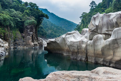 River water with naturally formed white shiny stone in unique shape at dry river bed at morning