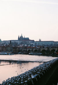 Bridge over river in city against clear sky