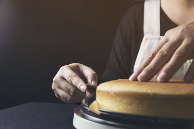 Midsection of man preparing cake