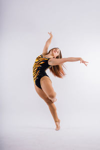 Full length of woman exercising against white background