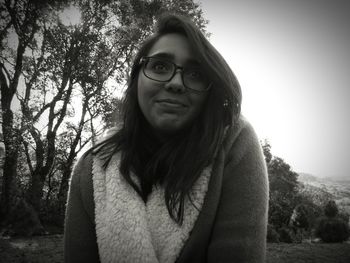 Close-up of young woman wearing sunglasses against trees