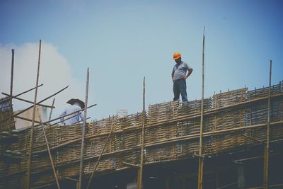 Man working at construction site against sky