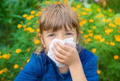 Portrait of sick girl having allergy wiping nose