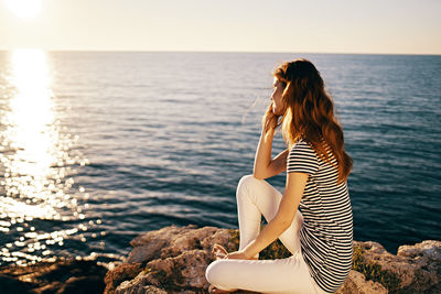 Woman looking at sea against sky