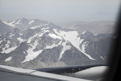 Scenic view of snowcapped mountains seen through car windshield