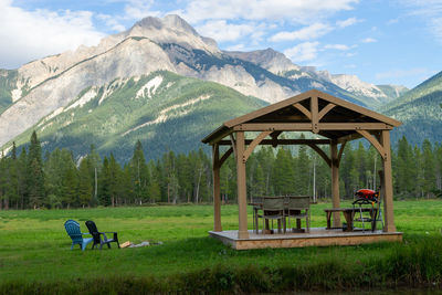 Gazebo on field against mountains