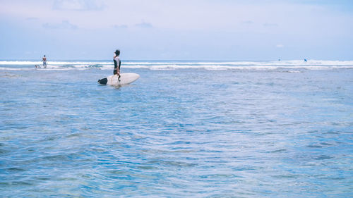 Man swimming in sea against sky