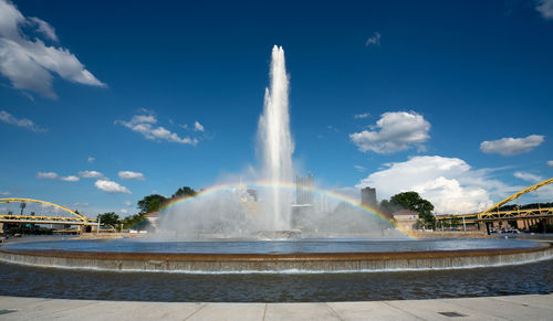 Fountain in city against sky