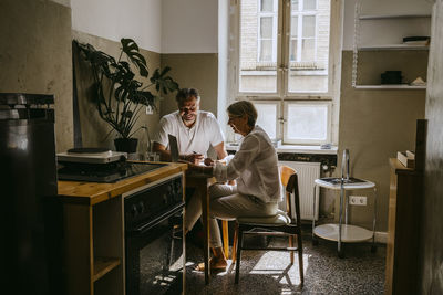 Smiling businessman discussing with mature female colleague in office