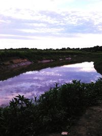 Scenic view of lake against cloudy sky