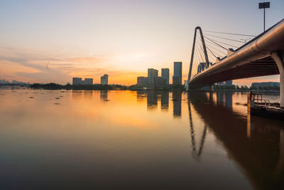 Bridge over river against sky during sunset