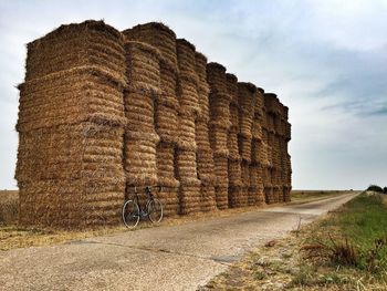 Bicycle parked by stacked hay