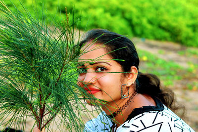 Portrait of young woman with plants