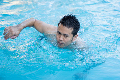 Portrait of man swimming in pool