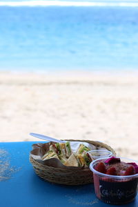 Close-up of fruits in basket on table at beach