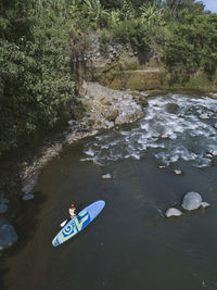 Surfer with sup surfboard at river