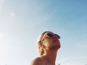Low angle view of woman in sunglasses against clear sky