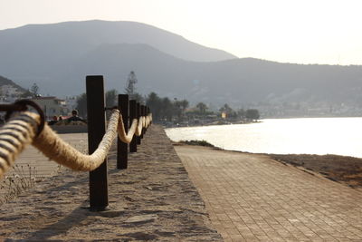 Close-up of mobile phone by lake against sky