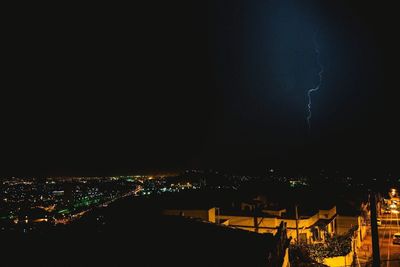 Illuminated cityscape against sky at night