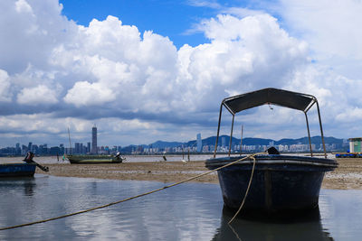 Sailboats moored at harbor against sky