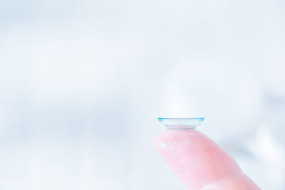 Close-up of hand holding bottle against blurred background