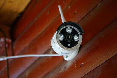 Close-up of security camera on wooden wall