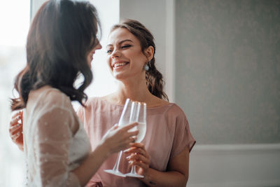 Bridesmaid and bride holding champagne flute