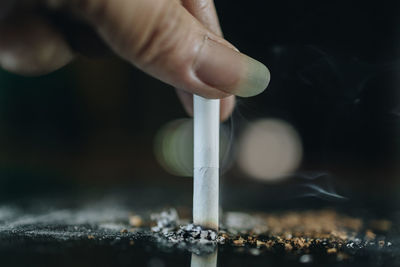 Close-up of hand holding cigarette