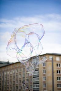 Low angle view of bubbles against buildings in city