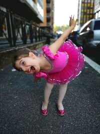 Portrait of happy girl bending on road