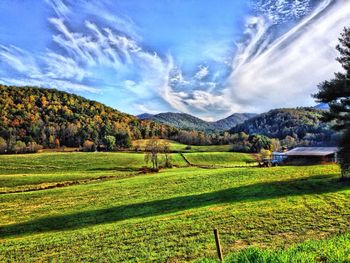 Scenic view of grassy field against cloudy sky