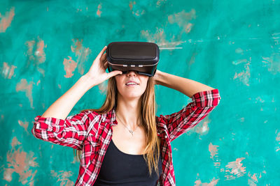 Woman standing outdoors wearing virtual reality headset