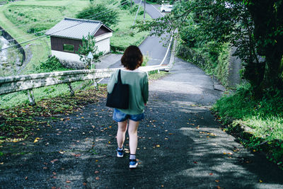 Rear view of woman standing by plants