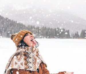 Young woman catching snowflakes with her mouth. winter, snow, outdoors.