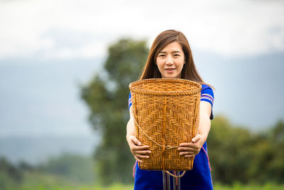 Portrait of smiling young woman holding basket