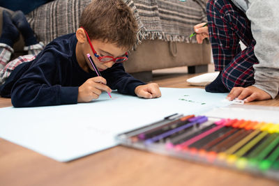 Boys using multi colored felt tip pen at home