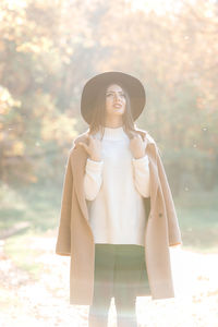 Portrait of young woman standing on field