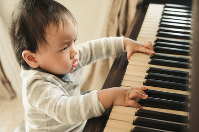 Boy playing piano at home