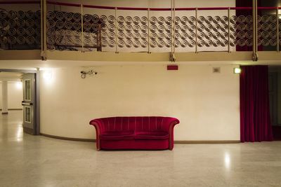 Empty red velvet couch at movie theater