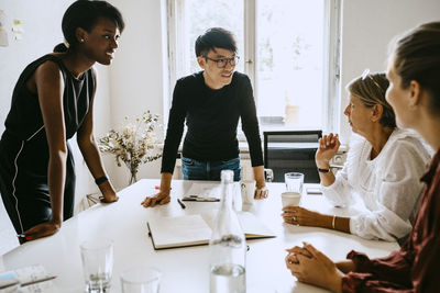 Businessman discussing with female colleagues during seminar in office