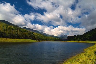 Scenic view of lake by mountains against sky