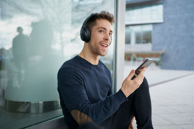 Young man with headphones on city street