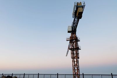 Low angle view of communications tower against sky during sunset