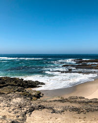 Scenic view of beach against clear sky