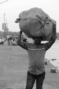 Full length of boy wearing hat against sky in city
