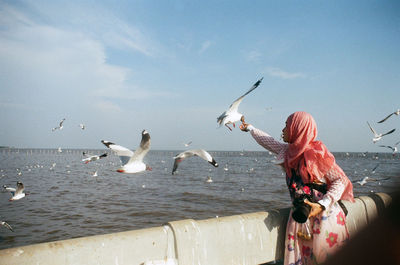 Seagulls flying over lake