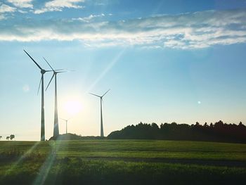 Windmill on field against sky during sunset