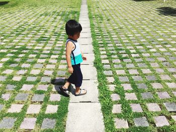 Side view of boy walking on footpath at park